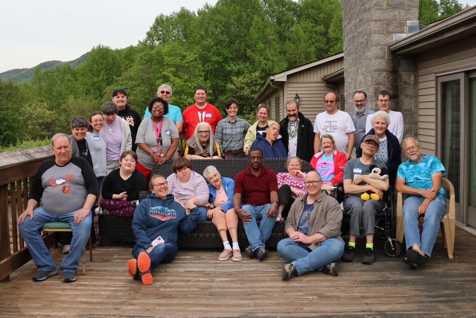 Members of Faith & Light attending their retreat pose for a group picture on the back deck of the lodge.