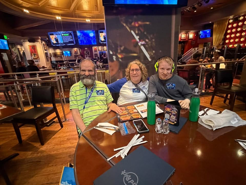Lex Pat and Cassidy sitting around a table at Baltimore's Hard Rock Cafe